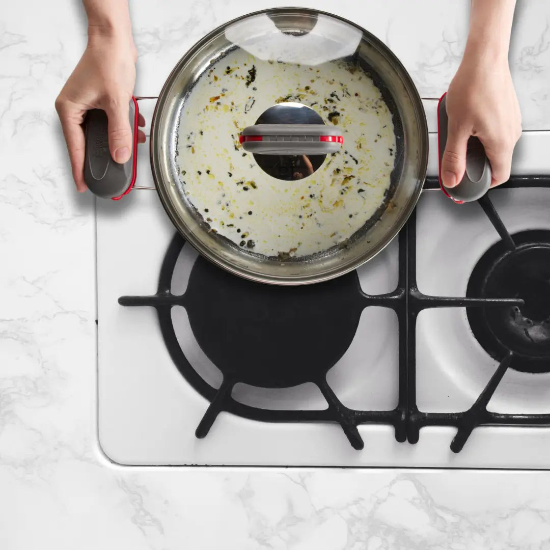 Red PebbleGrip locking onto a pan on stove top hob.