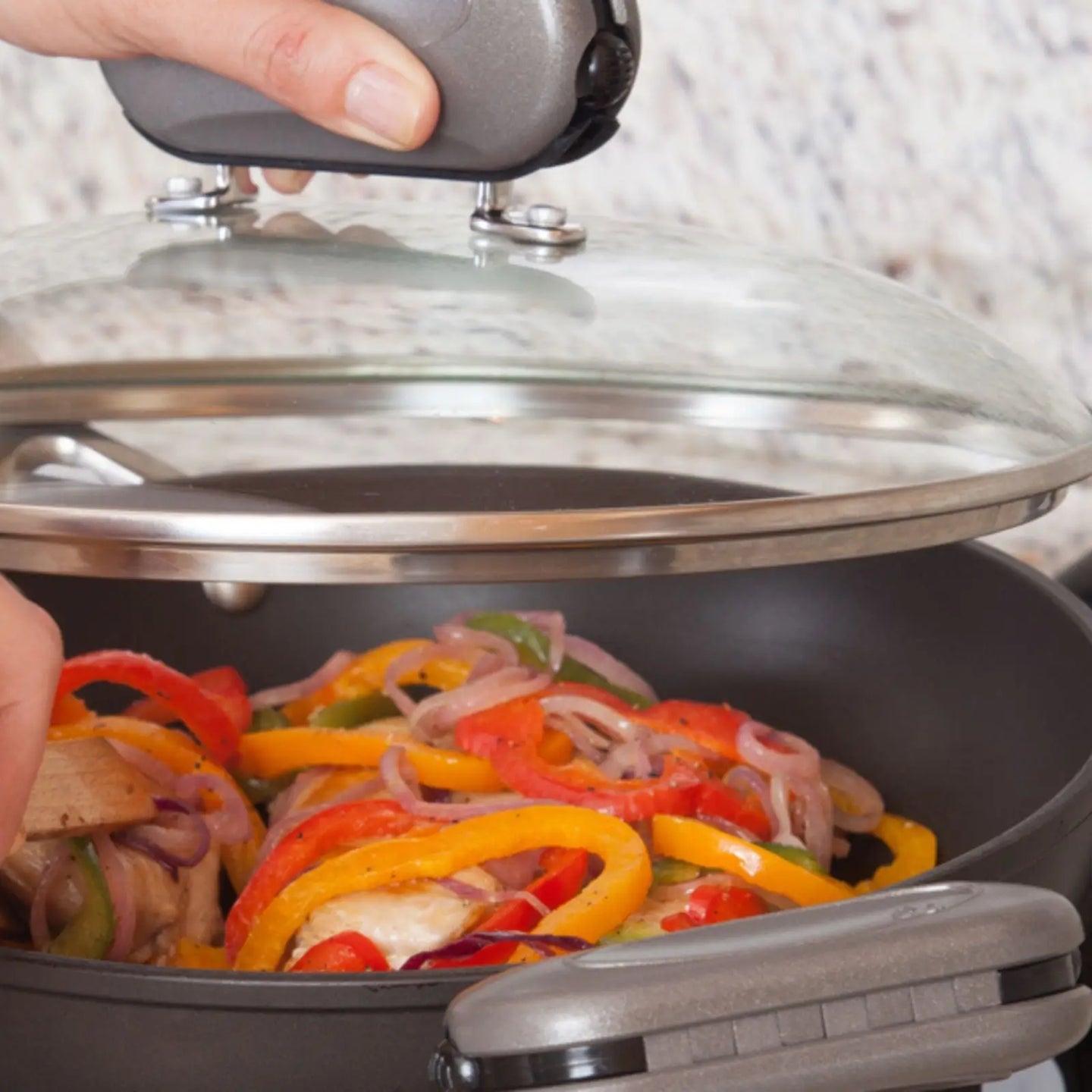 Pebblegrip clipped onto glass pan lids handle, lifting it off the cookware